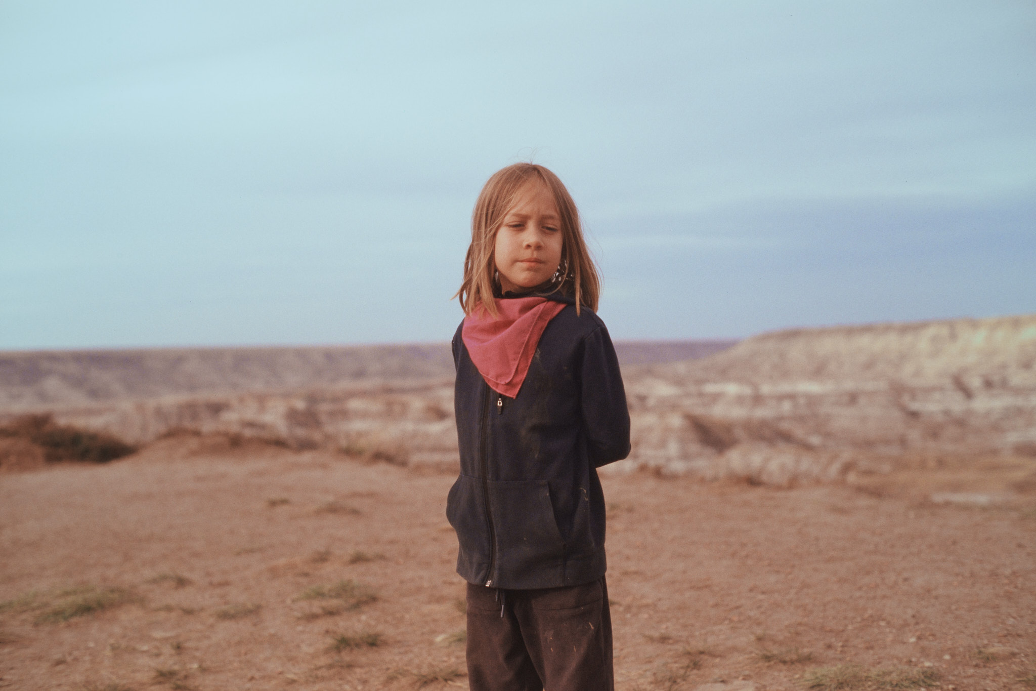 Child wearing a bandana standing in the badlands, medium format film