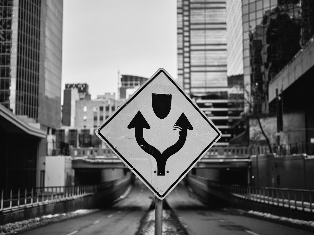 Road sign with Calgary downtown skyline — black and white urban photography