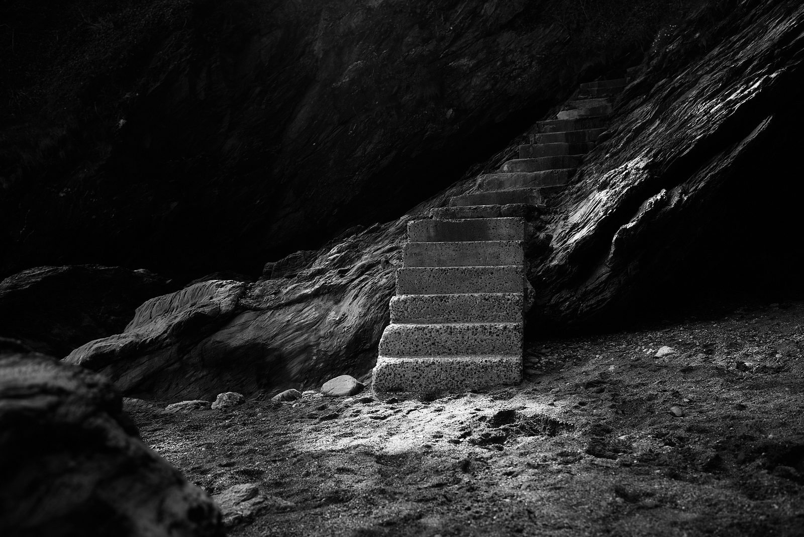 Stone steps carved into dark cave — black and white fine art photography