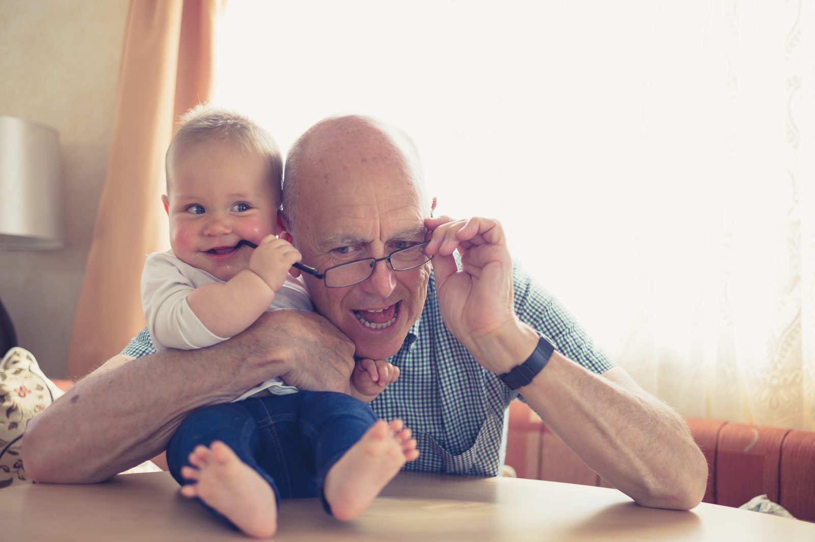 Grandfather playing with baby at table — family portrait photography Calgary